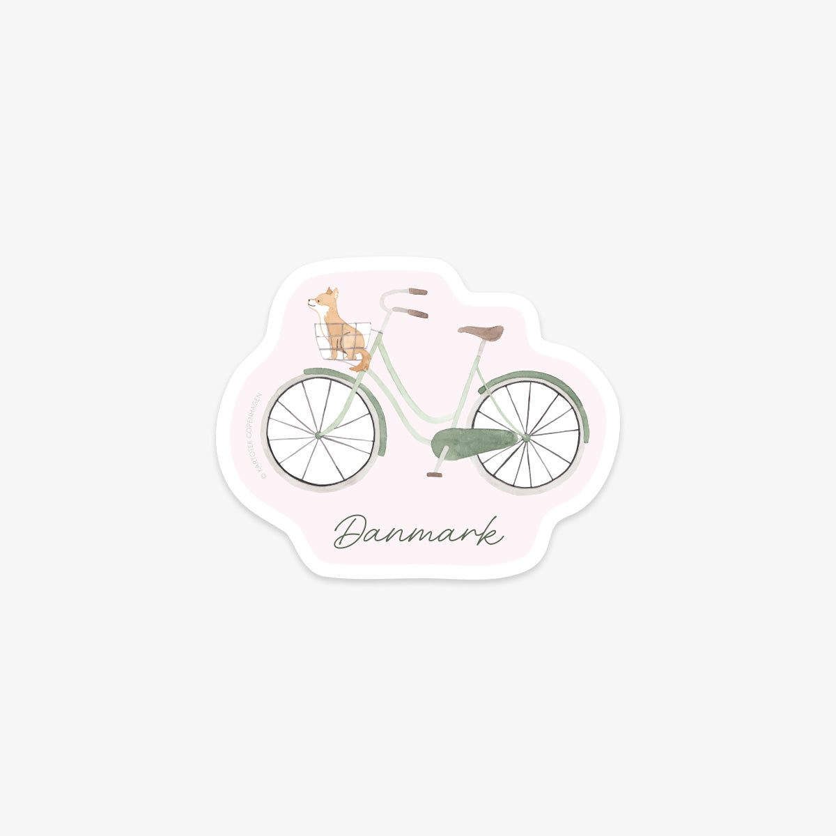 Vinyl sticker of a green and brown bicycle with a cute little dog in a basket, labeled 'Danmark' on a light pink background