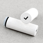 White wooden rubber stamps with a black band and check mark on a gray surface