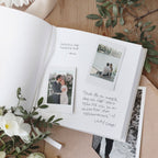 Open guestbook with blank pages and pictures