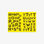 Sheet of black letter stencils on a yellow background