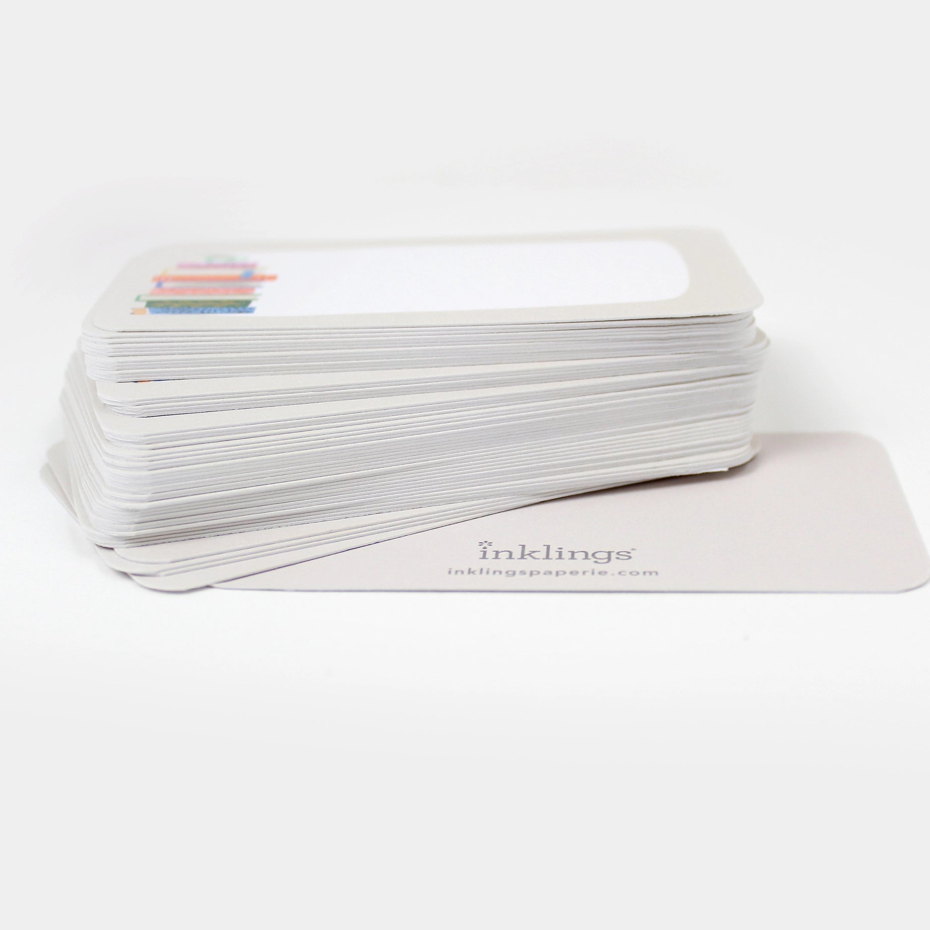 Stack of white cards with a book stack illustration and 'inklings' branding on a white background