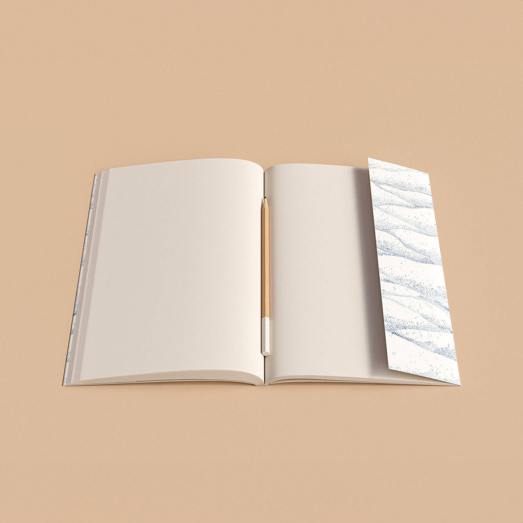 Open notebook with a pen on a beige background