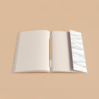 Open notebook with a pen on a beige background